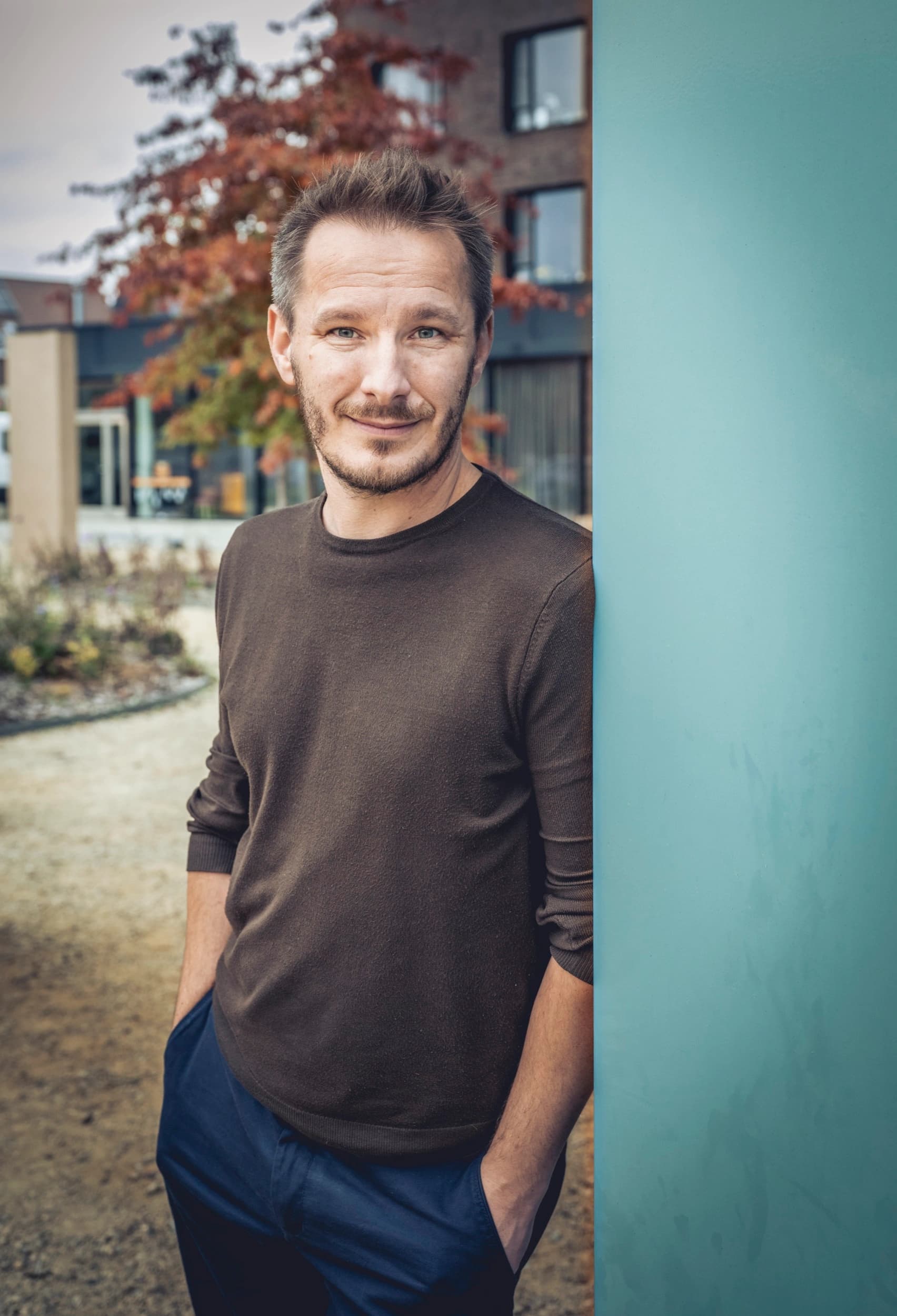 Portret van Pieter Deknudt, leunend tegen een muur